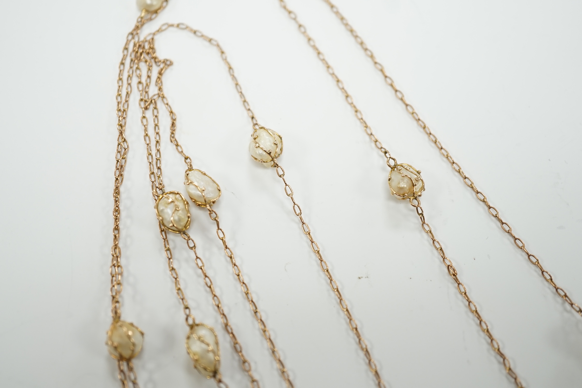 An early 20th century 9ct and eleven stone baroque pearl set long chain, 160cm, gross 13.2 grams.